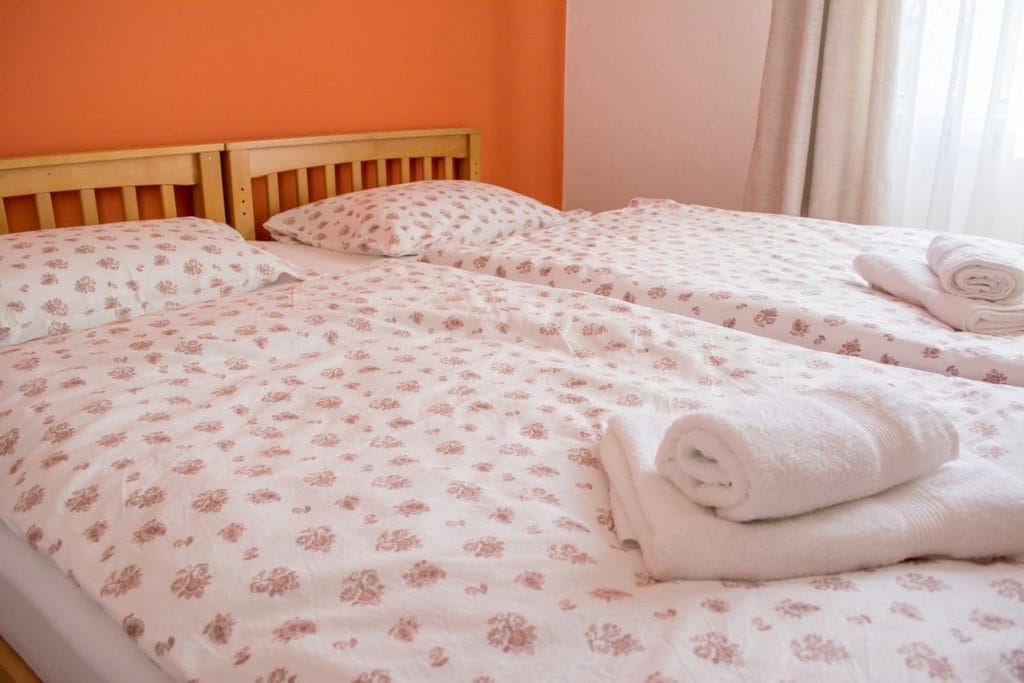 A double bed with clean towels waiting for the arrival of guests to Soča valley.