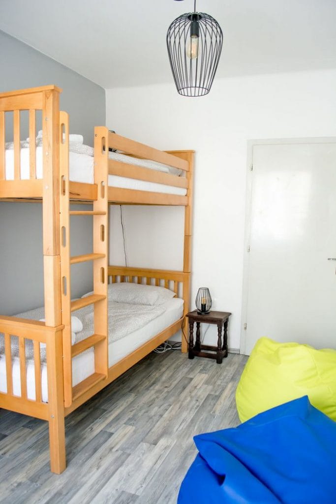 A sleeping room with a bunkbed and colourful teardrop pillows.