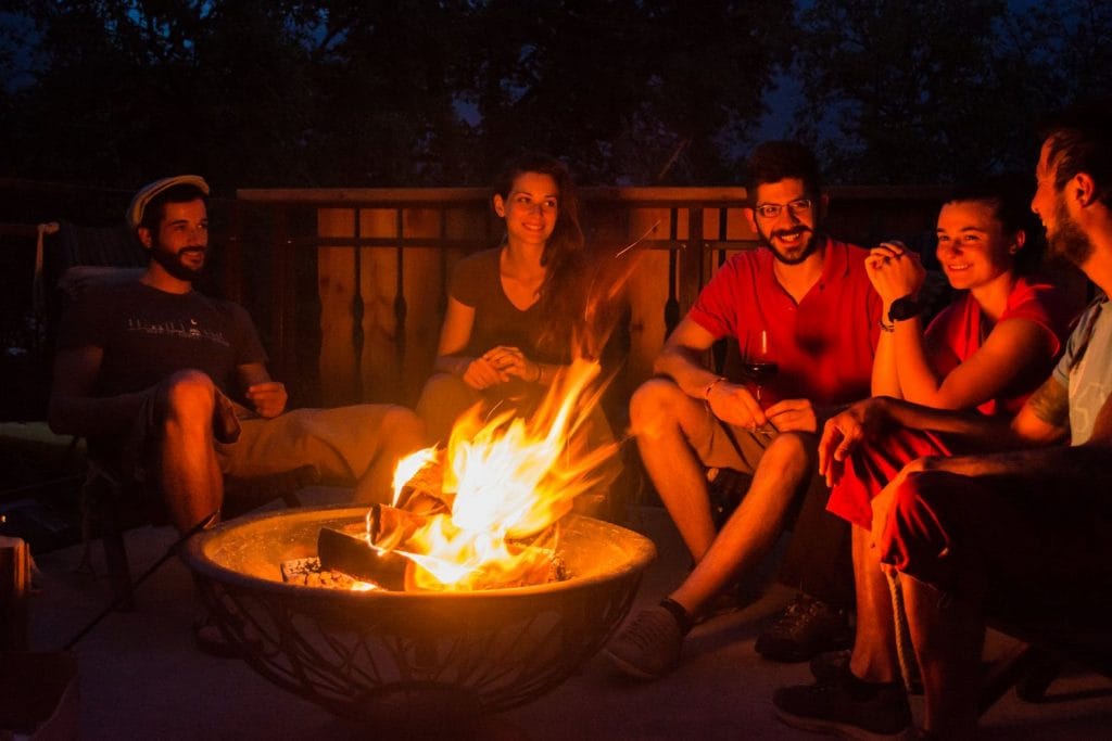 A group of friends having a good time by the fire a terrace in Summer House Kot.