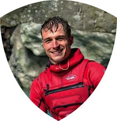 A portrait of a canyoning guide in his full gear. His name is Roman and he is in love with Soča river valley.